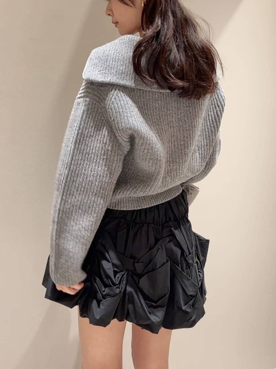 グレー系のニット/セーター、ブラック系のブーツ、ブラック系のハンドバッグを着用したレディースの冬コーディネートの3枚目の写真