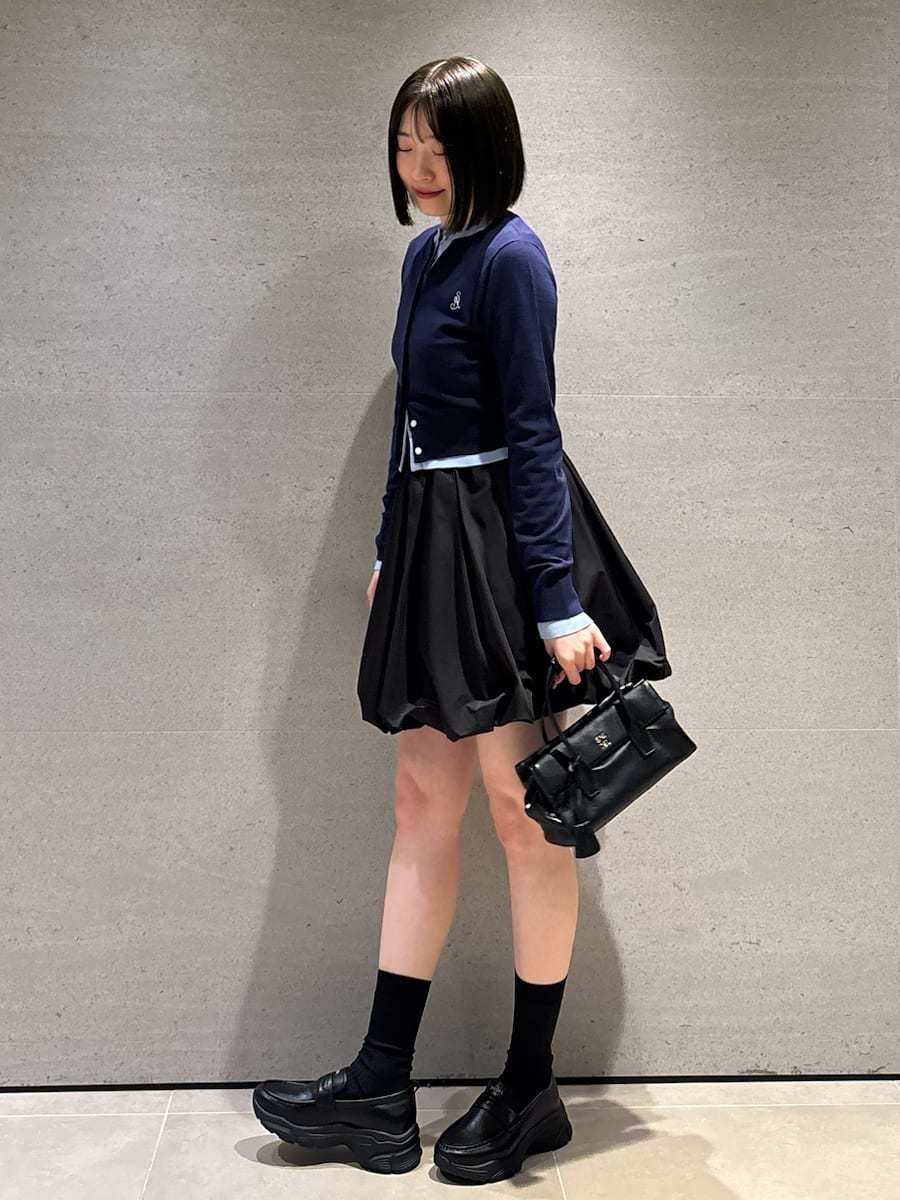 ブラック系のボストンバッグ、ブラック系のその他パンツ、ブルー系のカーディガン/ボレロを着用したレディースの冬コーディネートの3枚目の写真