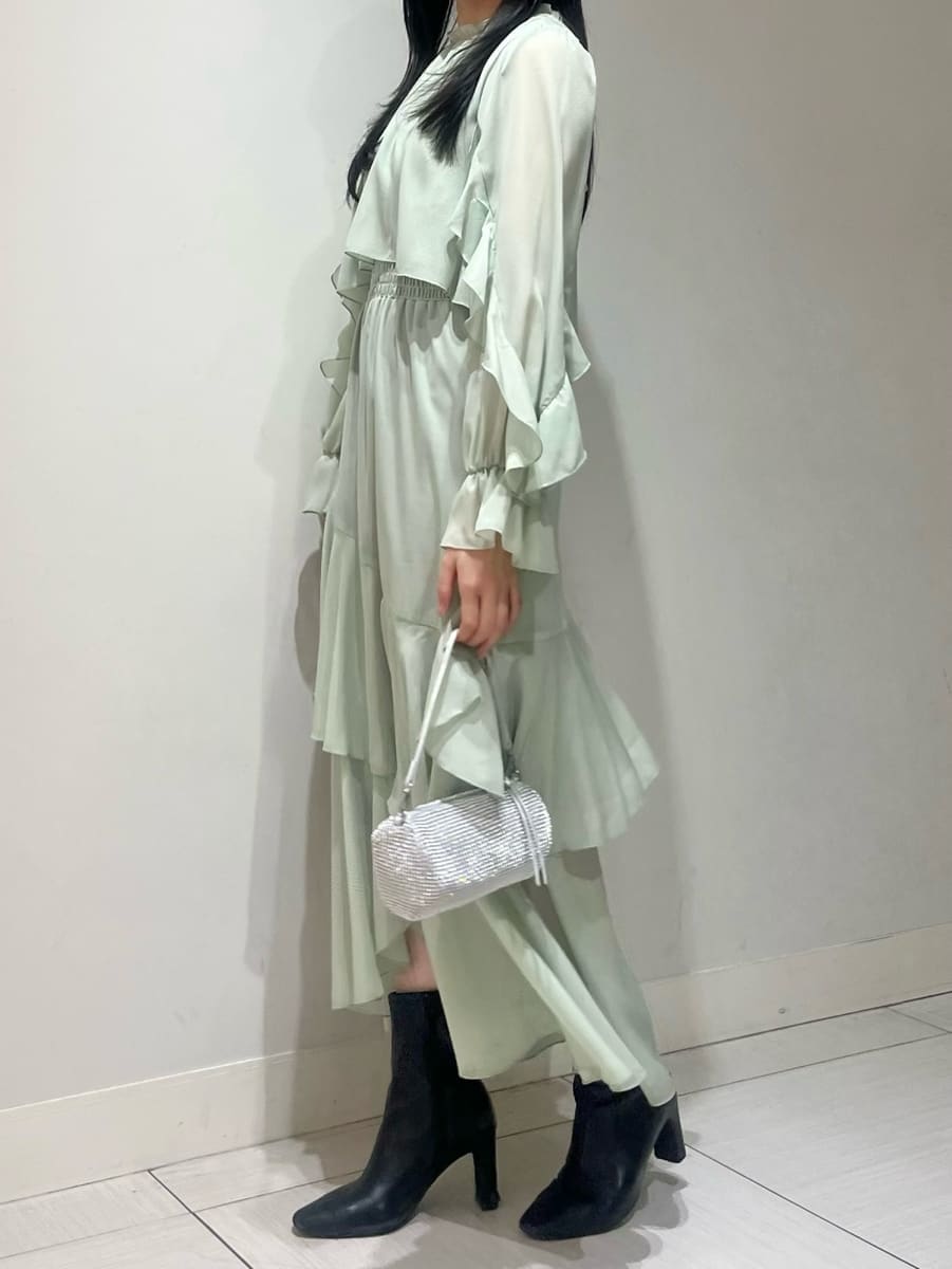 ブラック系のブーツ、ベージュ系のピーコート、グリーン系のワンピースを着用したレディースの冬コーディネートの5枚目の写真