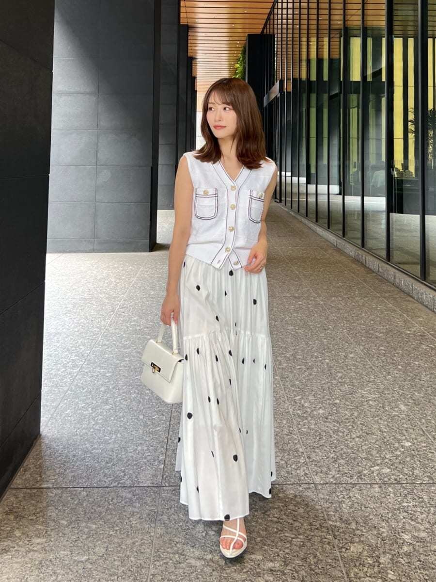 ホワイト系のニット/セーター、その他のスカート、ホワイト系のショルダーバッグを着用したレディースの夏コーディネートの2枚目の写真