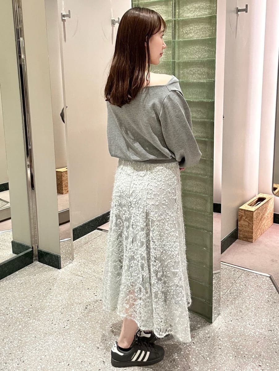 グレー系のTシャツ/カットソー、グリーン系のスカート、グレー系のスニーカーを着用したレディースの秋コーディネートの5枚目の写真