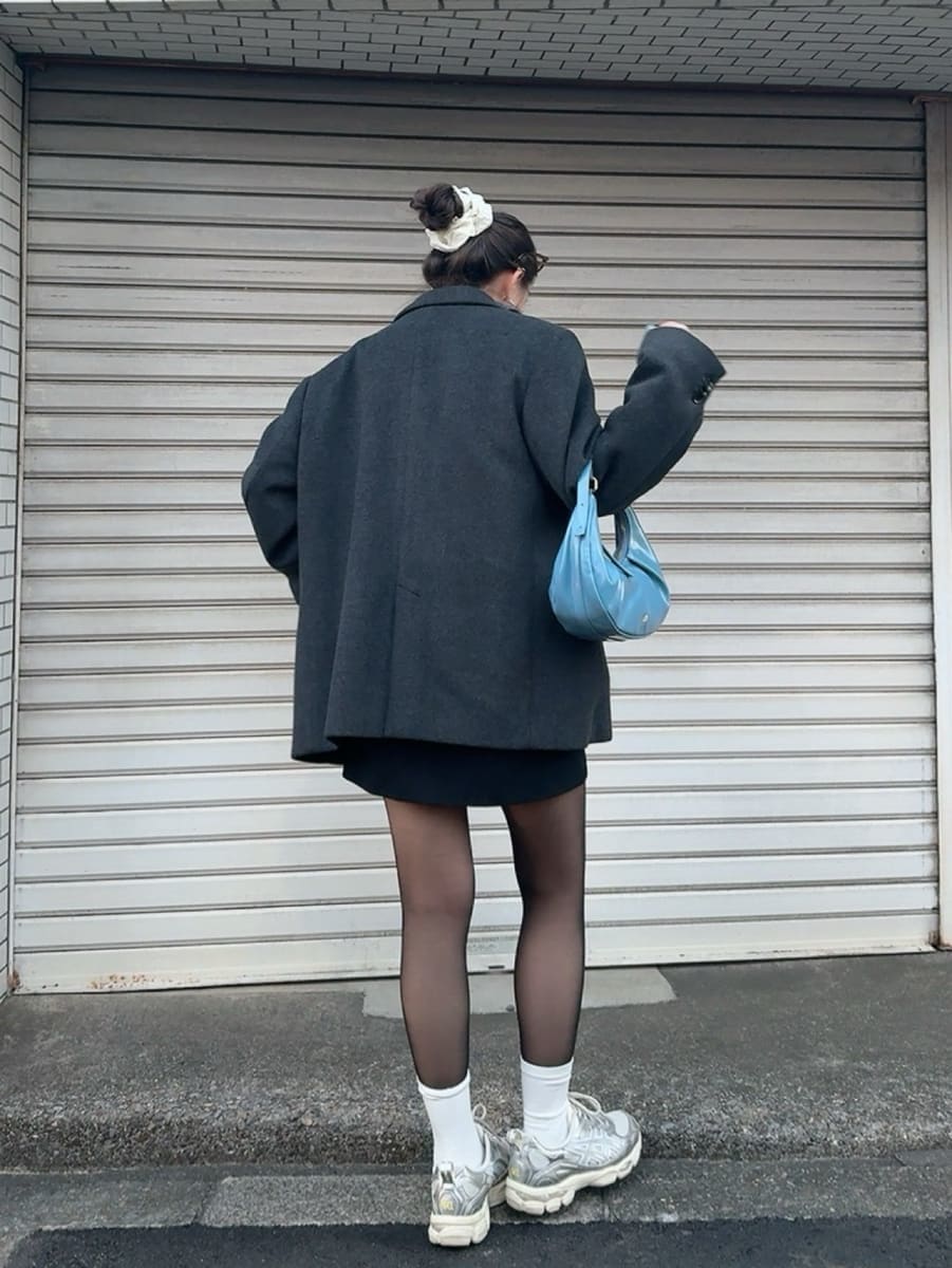 グレー系のニット/セーター、グレー系のテーラードジャケットを着用したレディースの冬コーディネートの3枚目の写真