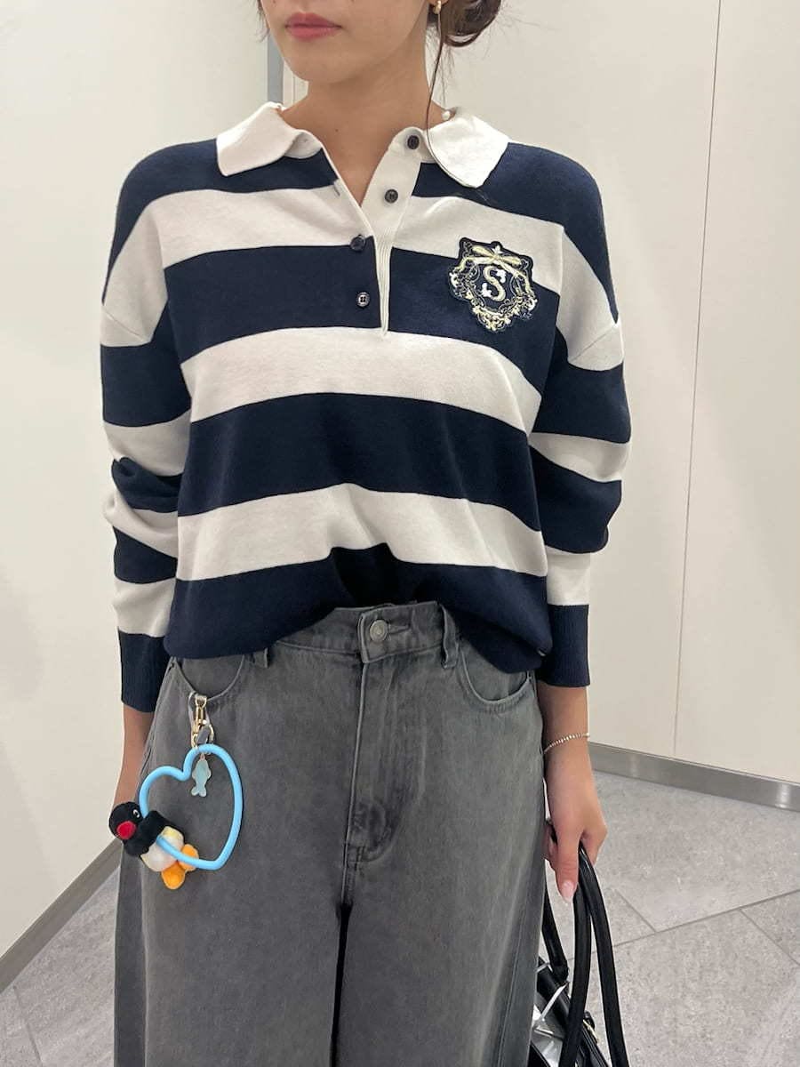 グレー系のデニムパンツ、ブルー系のポロシャツ、ブラック系のボストンバッグを着用したレディースの夏コーディネートの4枚目の写真