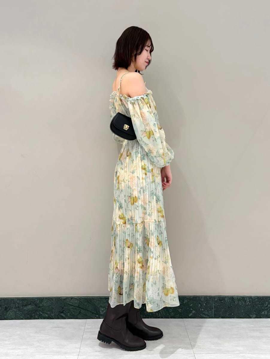 グリーン系のワンピース、ブラック系のショルダーバッグ、その他のイヤリングを着用したレディースの春コーディネートの3枚目の写真