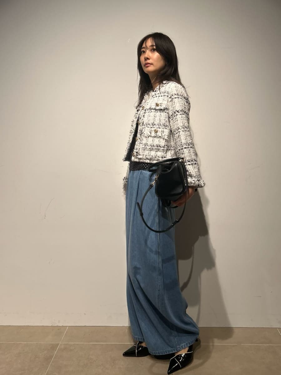 ホワイト系のノーカラージャケット、ブラック系のキャミソール、ブラック系のパンプスを着用したレディースの春コーディネートの3枚目の写真