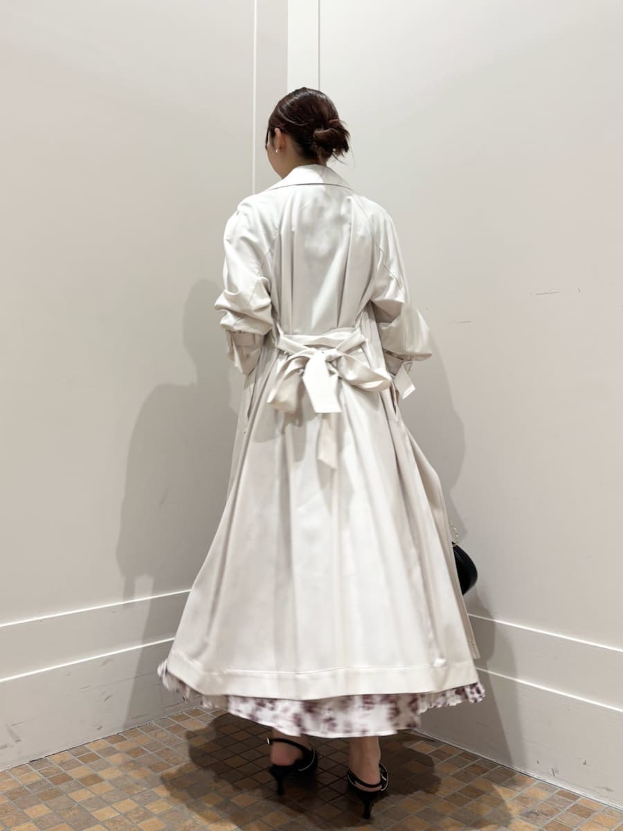 ホワイト系のトレンチコート、ピンク系のワンピース、ブラック系のパンプスを着用したレディースの冬コーディネートの3枚目の写真