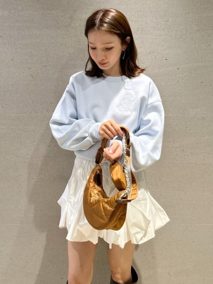 ブルー系のスウェット、イエロー系のショルダーバッグ、ホワイト系のその他パンツを着用したレディースの冬コーディネートの4枚目の写真