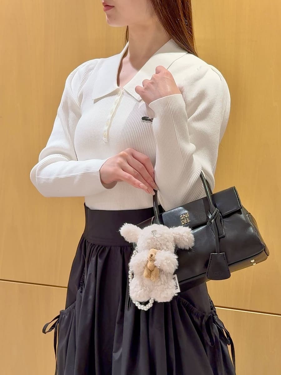 ホワイト系のニット/セーター、ブラック系のスカート、その他のブーツを着用したレディースの秋コーディネートの7枚目の写真