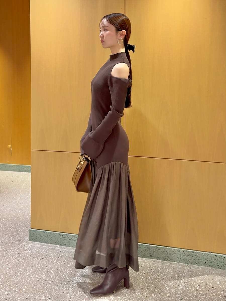 レッド系のブーツ、ブラウン系のワンピース、ブラウン系のハンドバッグを着用したレディースの秋コーディネートの2枚目の写真