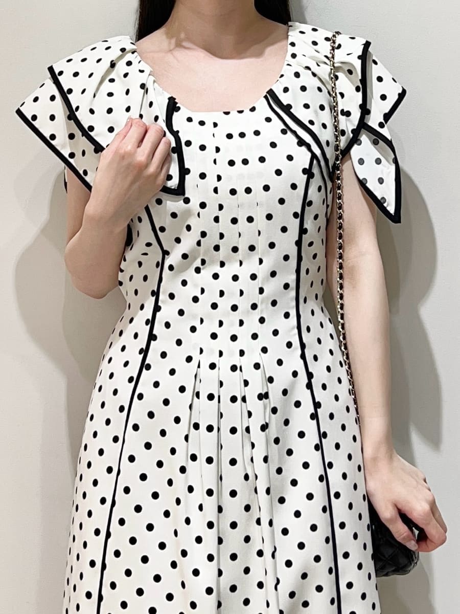 ホワイト系のワンピース、ブラック系のパンプスを着用したレディースの春コーディネートの2枚目の写真