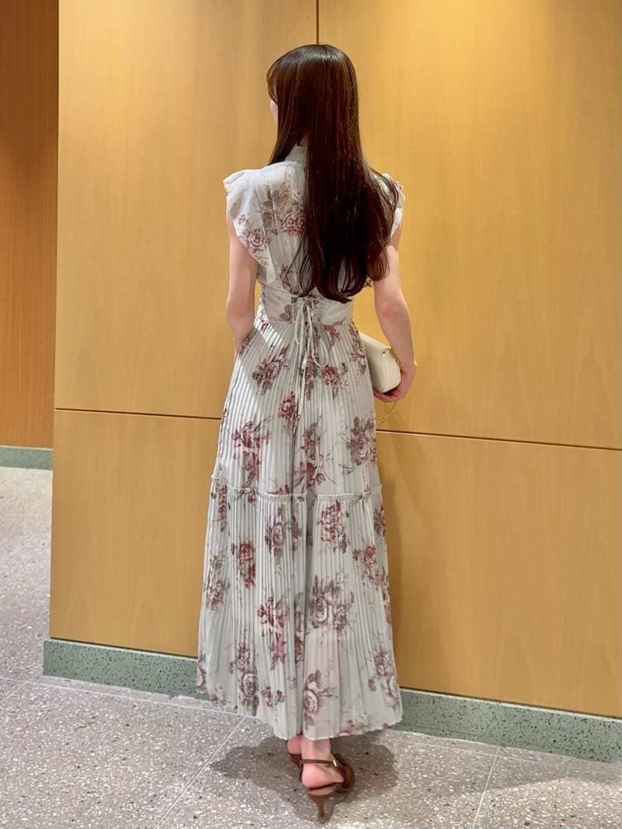 グリーン系のワンピース、ブラウン系のパンプス、ホワイト系のショルダーバッグを着用したレディースの春コーディネートの3枚目の写真