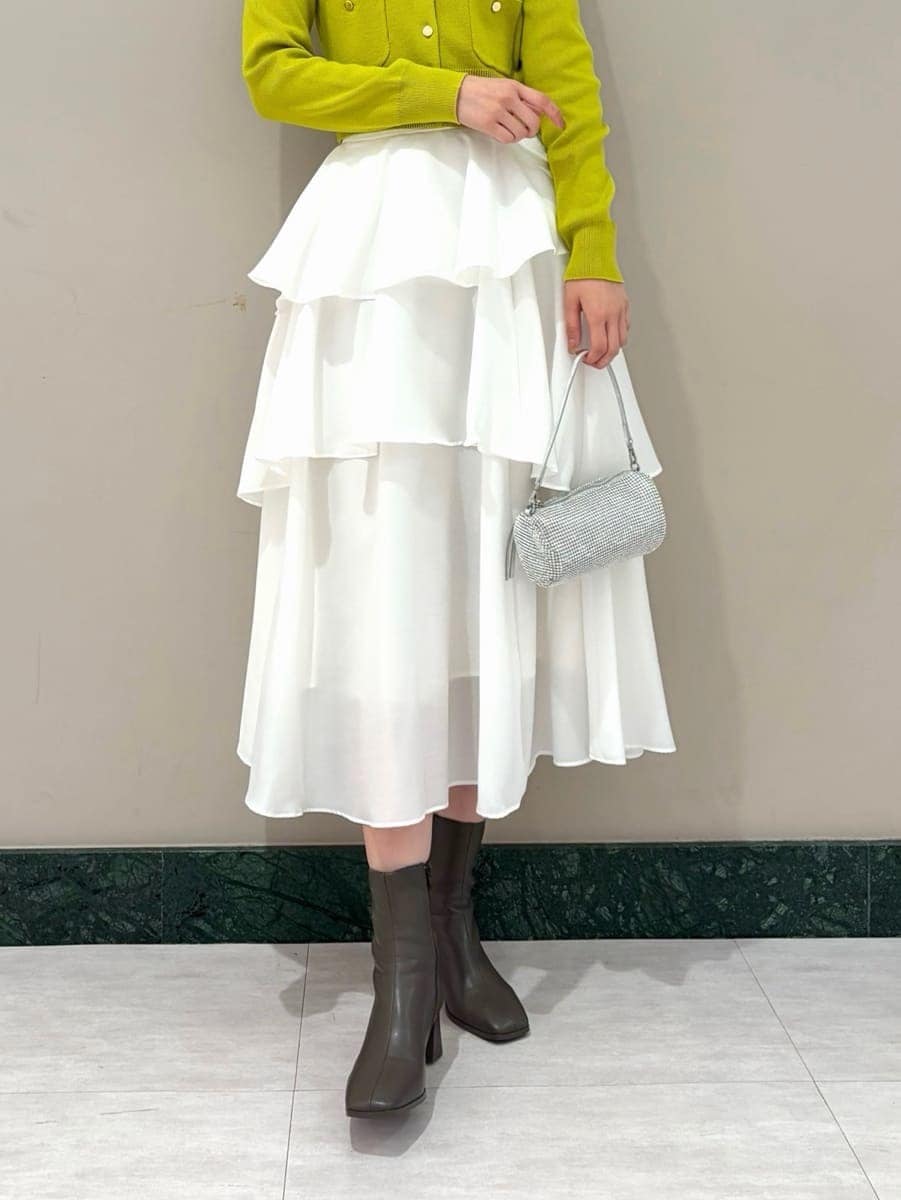 イエロー系のワンピース、ゴールド系のイヤリングを着用したレディースの冬コーディネートの4枚目の写真