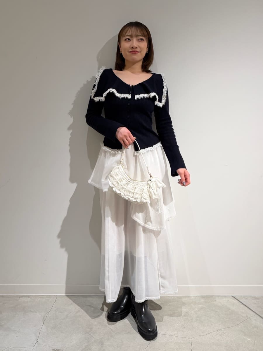 ブラック系のブーツ、ホワイト系のスカート、ブルー系のニット/セーターを着用したレディースの冬コーディネートの3枚目の写真