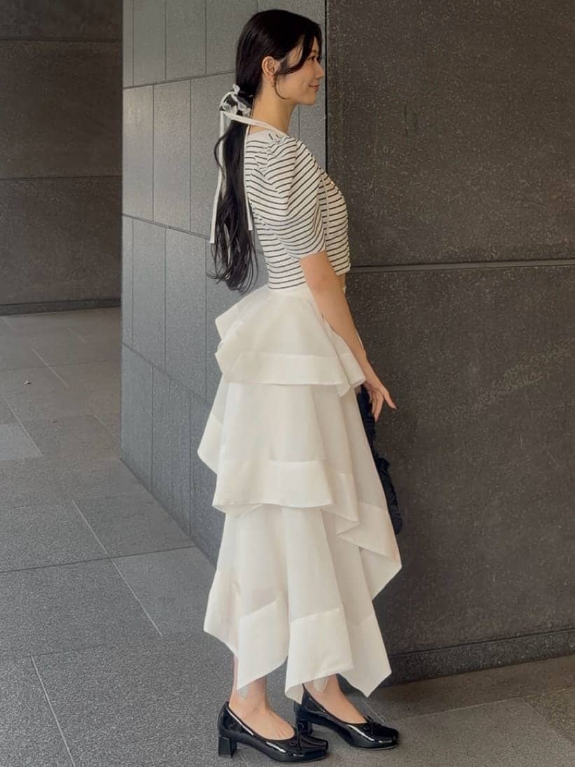 ホワイト系のスカート、その他のカーディガン/ボレロ、ブラック系のパンプスを着用したレディースの春コーディネートの2枚目の写真