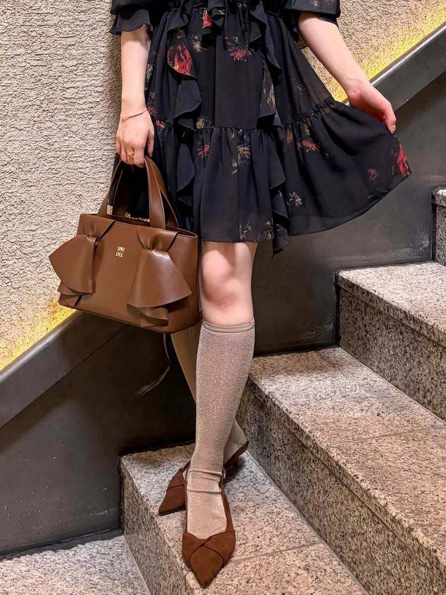 ブラック系のその他トップス、ブラウン系のパンプス、ブラウン系のハンドバッグを着用したレディースの春コーディネートの5枚目の写真