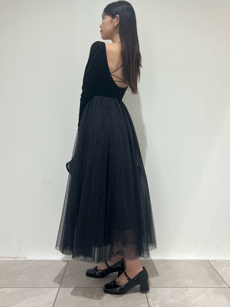 ブラック系のワンピース、ブラック系のハンドバッグ、ブラック系のパンプスを着用したレディースの夏コーディネートの2枚目の写真