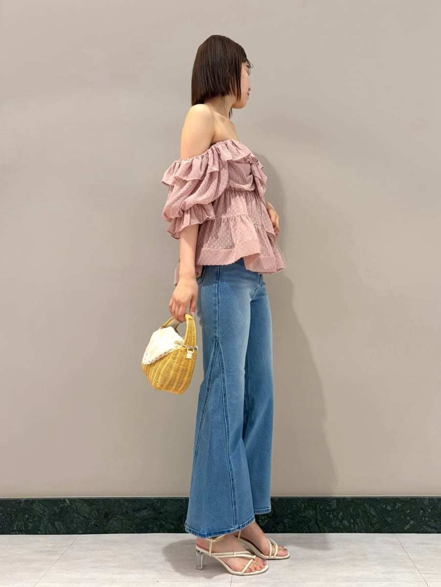 ブルー系のデニムパンツ、ホワイト系のサンダル、ホワイト系のかごバッグを着用したレディースの夏コーディネートの3枚目の写真