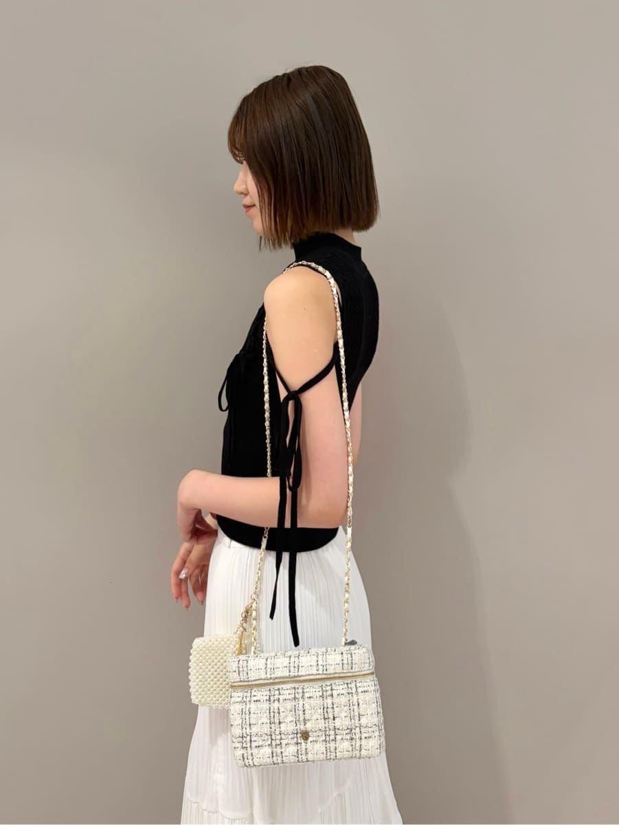 ホワイト系のサンダル、ホワイト系のスカート、ブラック系のニット/セーターを着用したレディースの夏コーディネートの6枚目の写真