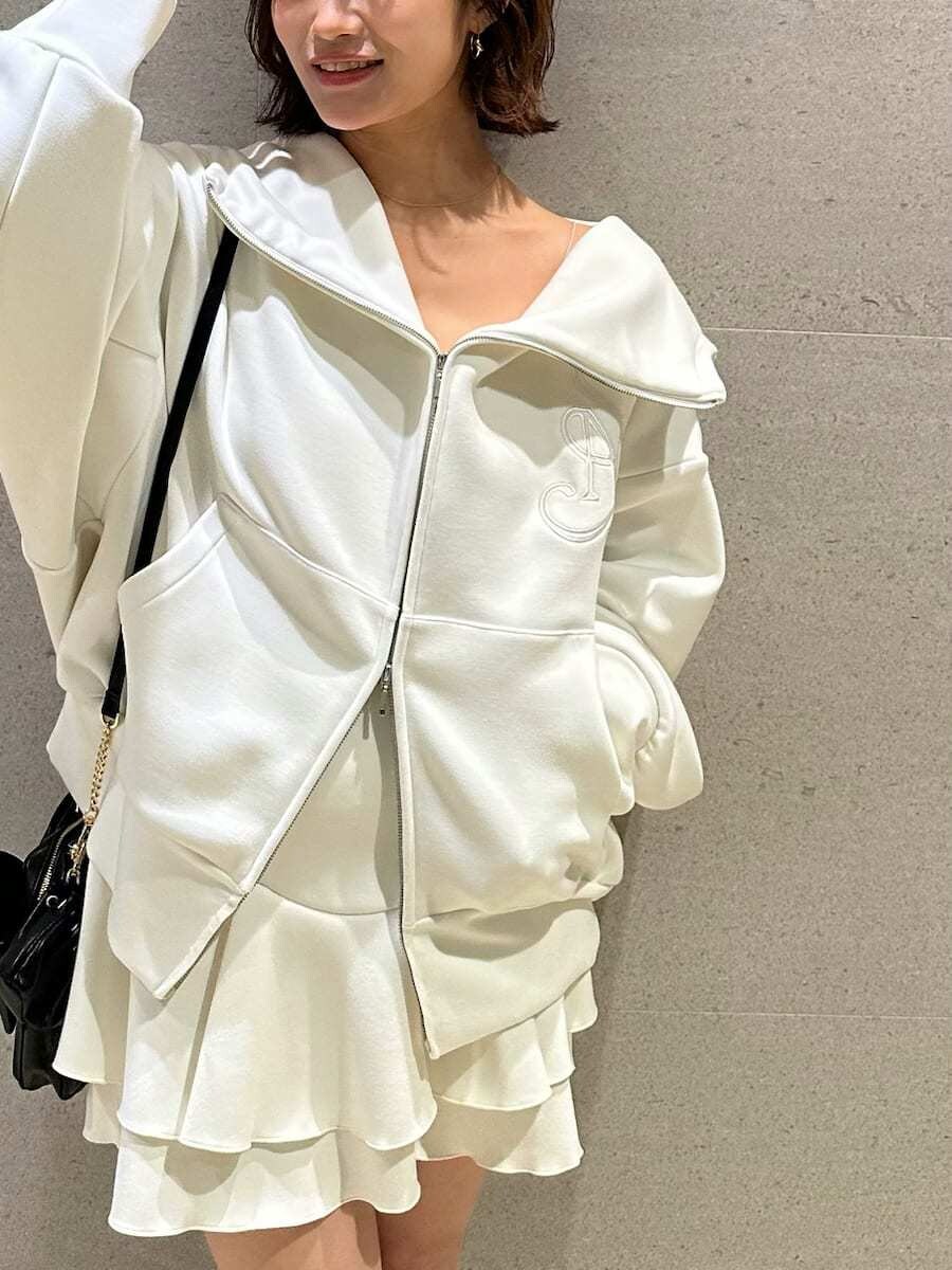 ホワイト系のパーカー、ホワイト系のブーツ、ブラック系のショルダーバッグを着用したレディースの冬コーディネートの2枚目の写真