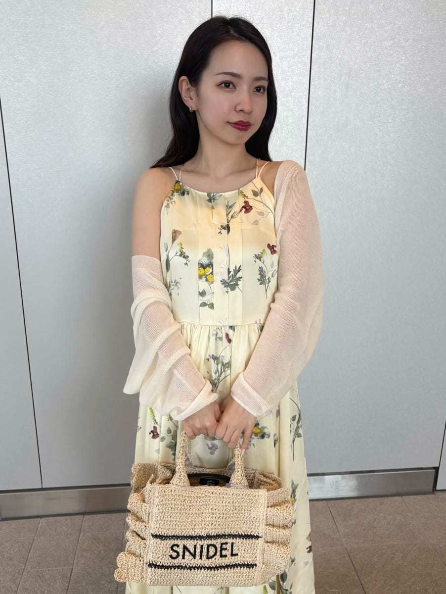 イエロー系のワンピース、ホワイト系のカーディガン/ボレロ、ベージュ系のショルダーバッグを着用したレディースの春コーディネートの7枚目の写真