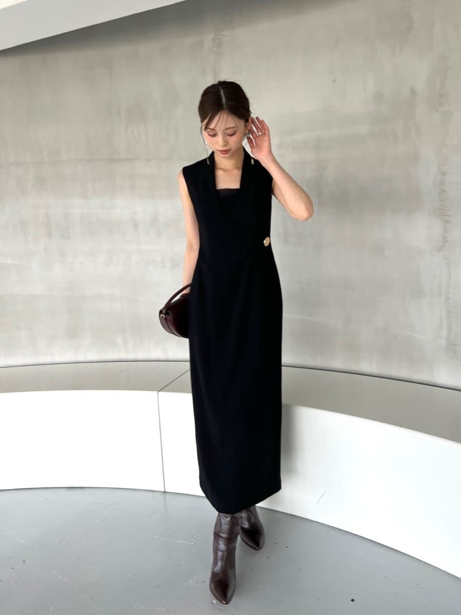 ブラック系のワンピース、ブラウン系のハンドバッグ、ブラウン系のブーツを着用したレディースの夏コーディネートの2枚目の写真