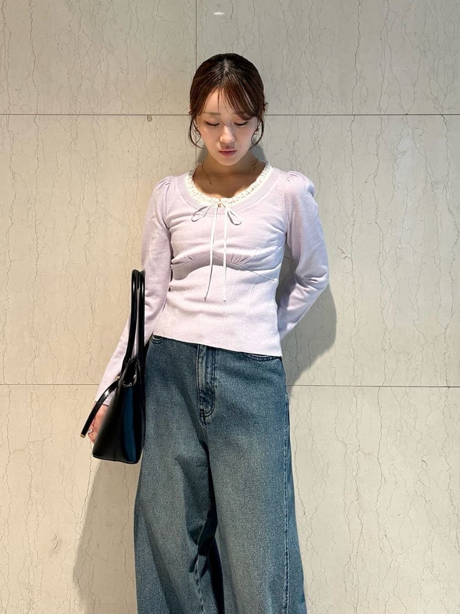 ブルー系のデニムパンツ、パープル系のニット/セーター、ブラック系のボストンバッグを着用したレディースの秋コーディネートの2枚目の写真