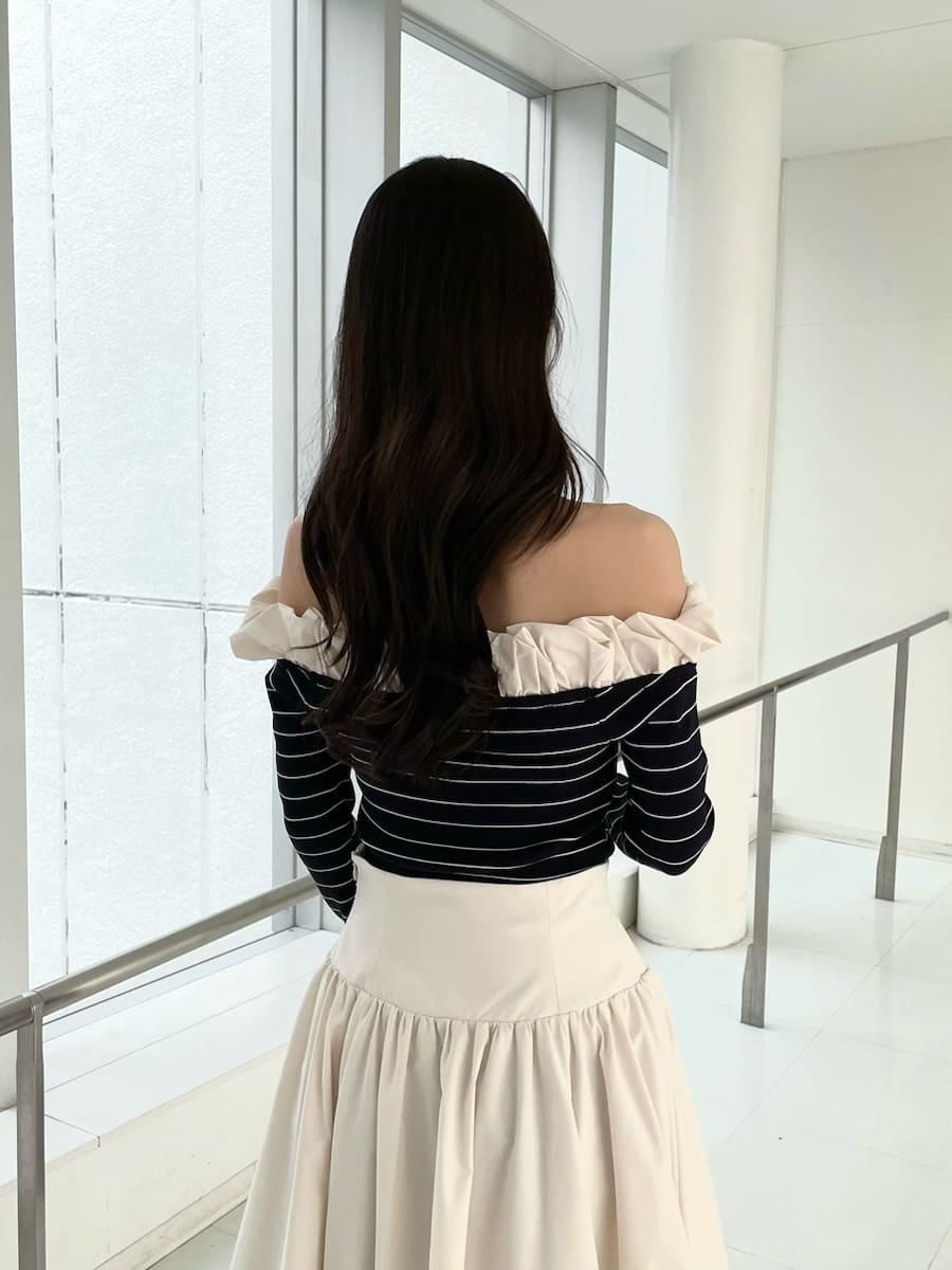 ブラック系のブーツ、ホワイト系のスカート、その他のニット/セーターを着用したレディースの冬コーディネートの5枚目の写真