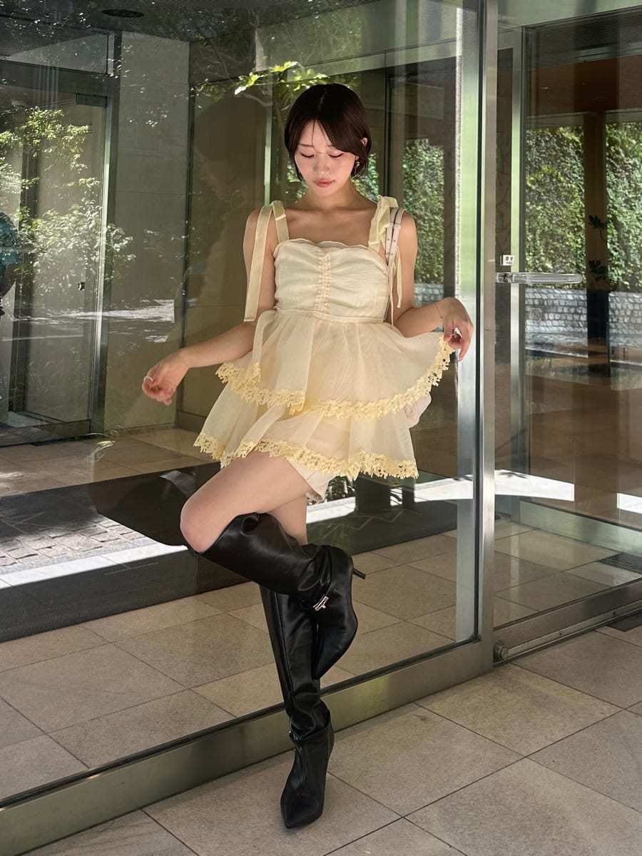 イエロー系のその他トップス、ブラック系のブーツ、ホワイト系のバックパック/リュックを着用したレディースの夏コーディネートの4枚目の写真