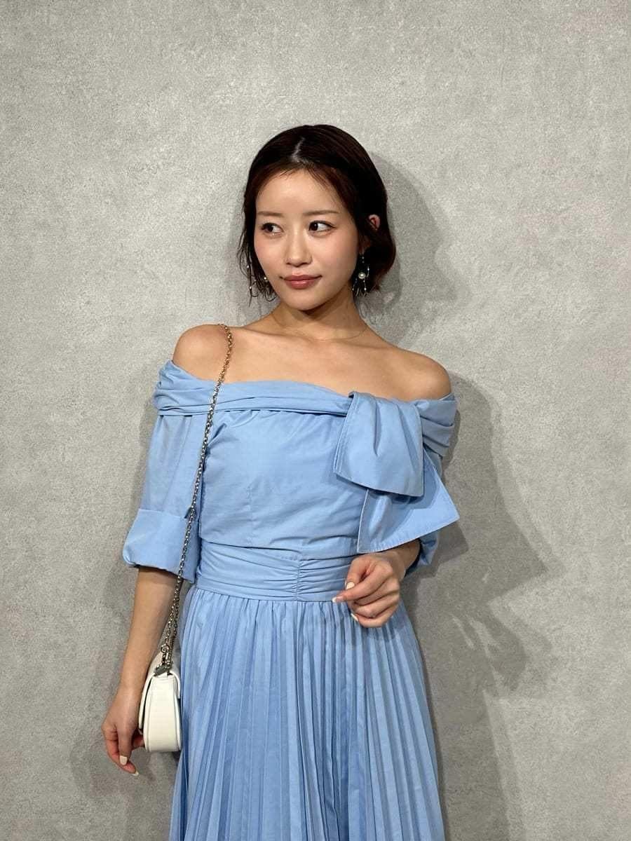 ブルー系のワンピース、その他のパンプス、ホワイト系のショルダーバッグを着用したレディースの冬コーディネートの6枚目の写真