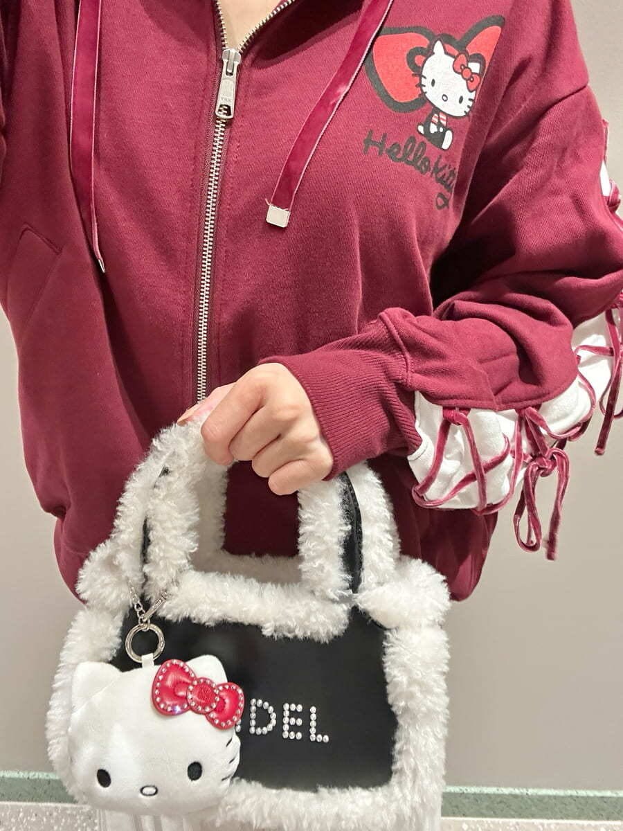 レッド系のパーカー、ホワイト系のスカート、ブラック系のハンドバッグを着用したレディースの秋コーディネートの7枚目の写真