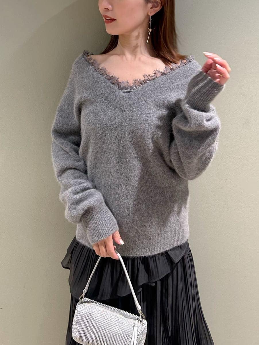 グレー系のブーツ、グレー系のニット/セーター、グレー系のスカートを着用したレディースの冬コーディネートの2枚目の写真