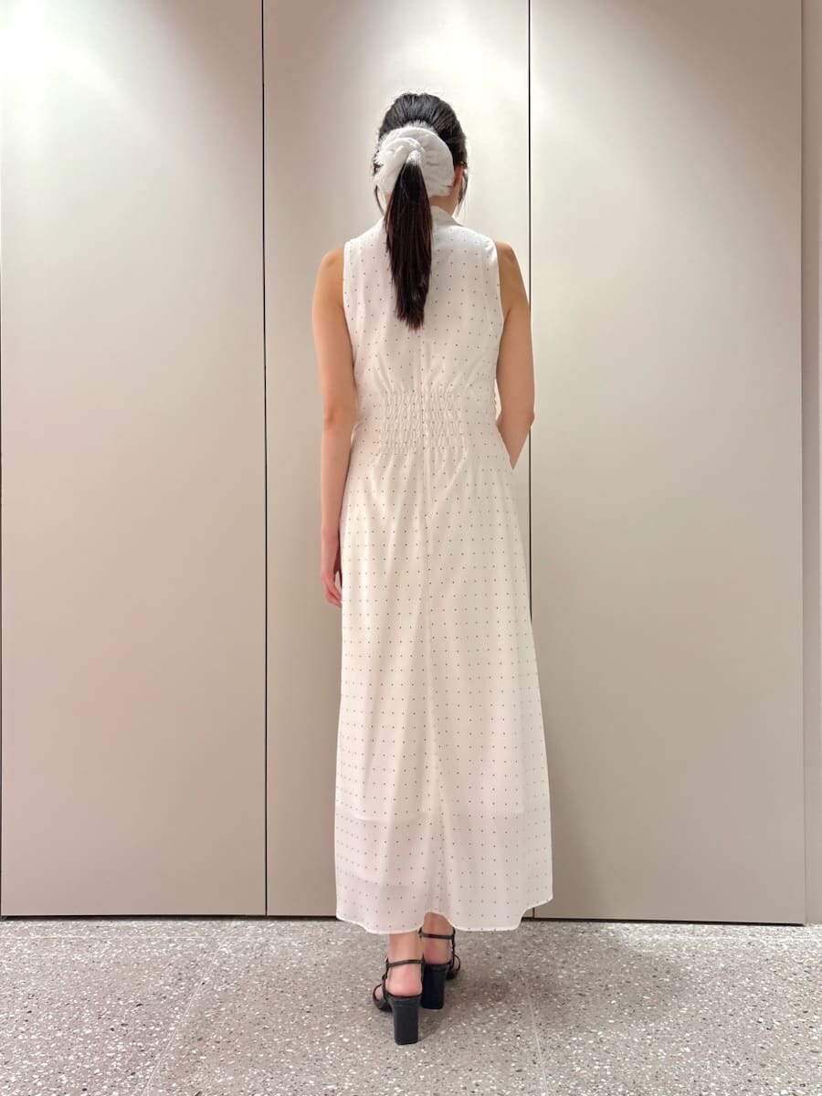 ホワイト系のワンピース、ブラック系のサンダル、シルバー系のハンドバッグを着用したレディースの春コーディネートの3枚目の写真