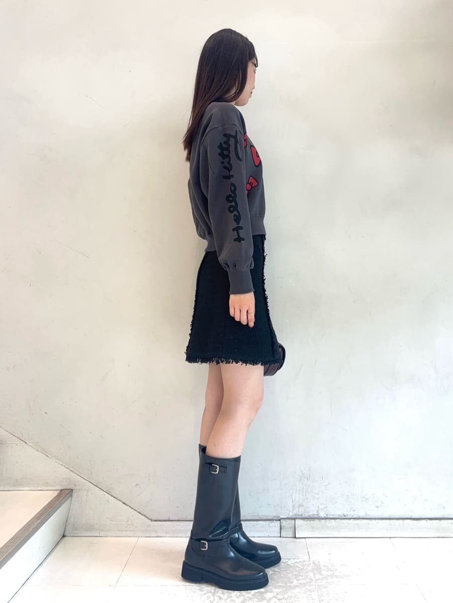 ブラック系のスウェット、ブラック系のスカート、ブラウン系のハンドバッグを着用したレディースの秋コーディネートの5枚目の写真