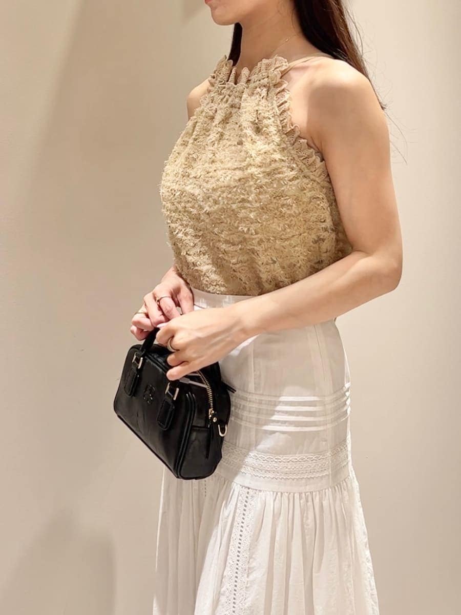 イエロー系のTシャツ/カットソー、ホワイト系のスカート、ブラック系のショルダーバッグを着用したレディースの夏コーディネートの6枚目の写真