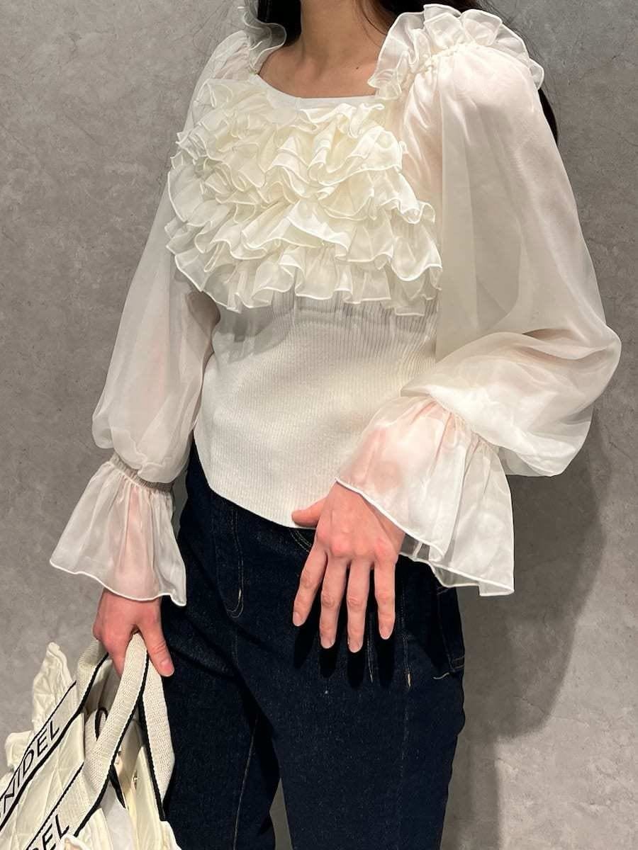 ブルー系のその他パンツ、ホワイト系のニット/セーター、ホワイト系のハンドバッグを着用したレディースの冬コーディネートの2枚目の写真