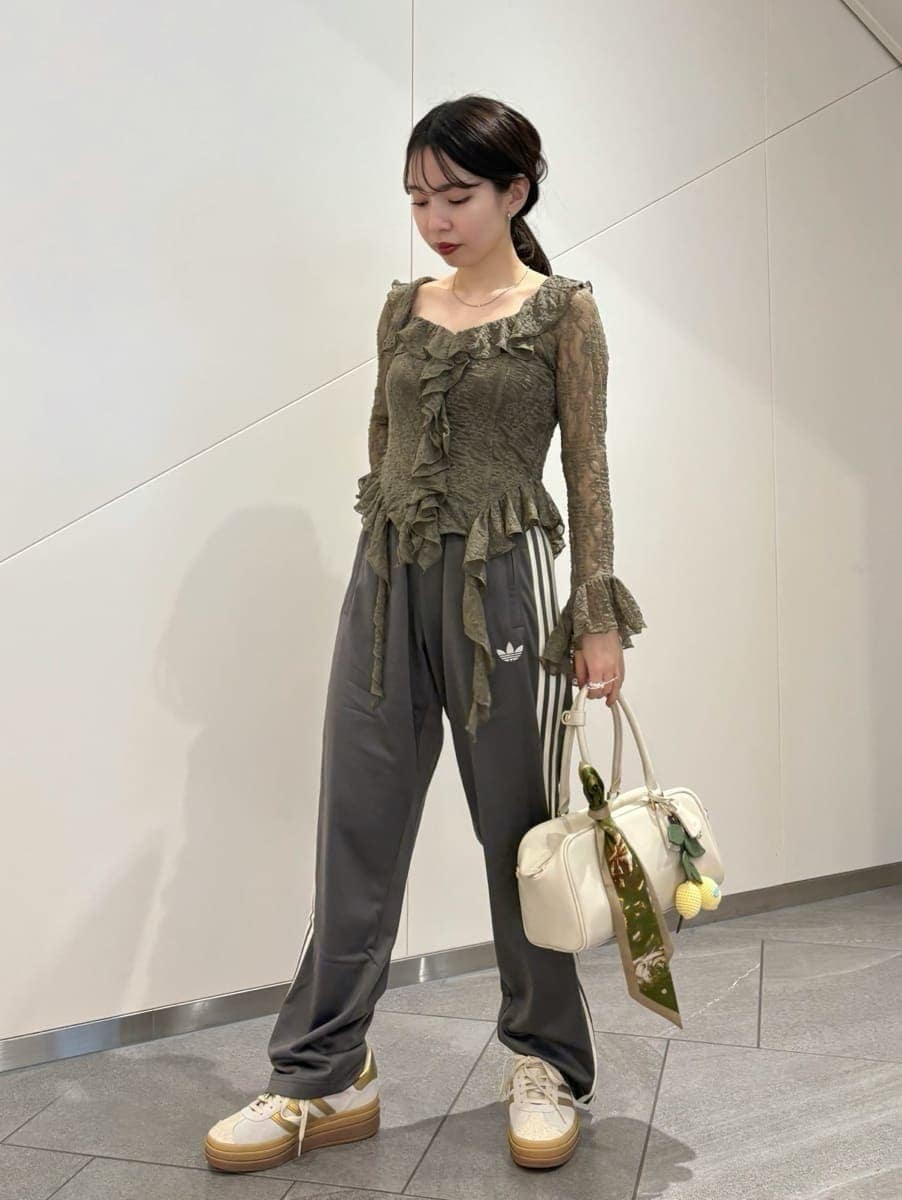 グリーン系のTシャツ/カットソー、グレー系のその他パンツ、ホワイト系のボストンバッグを着用したレディースの冬コーディネートの2枚目の写真