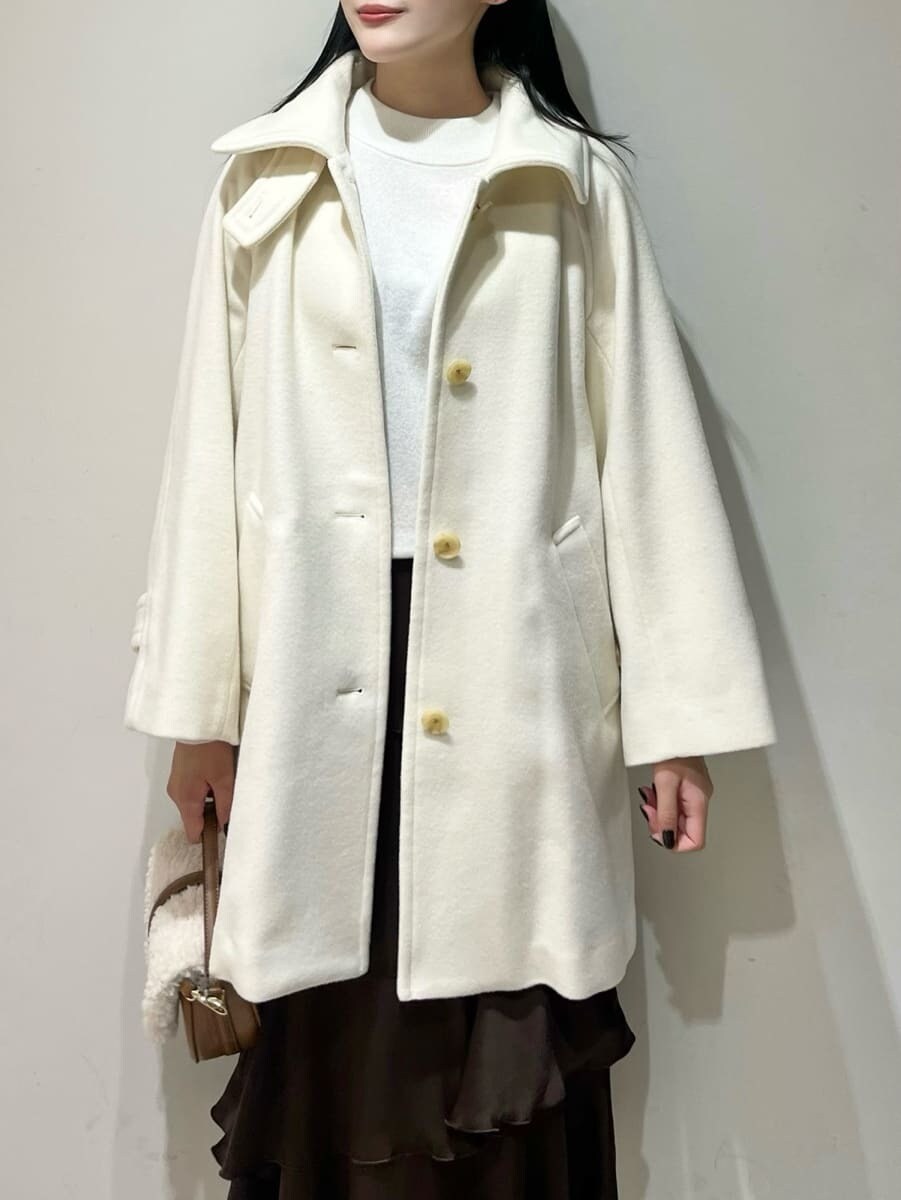 ホワイト系のニット/セーター、ブラウン系のスカート、ホワイト系のステンカラーコートを着用したレディースの秋コーディネートの4枚目の写真