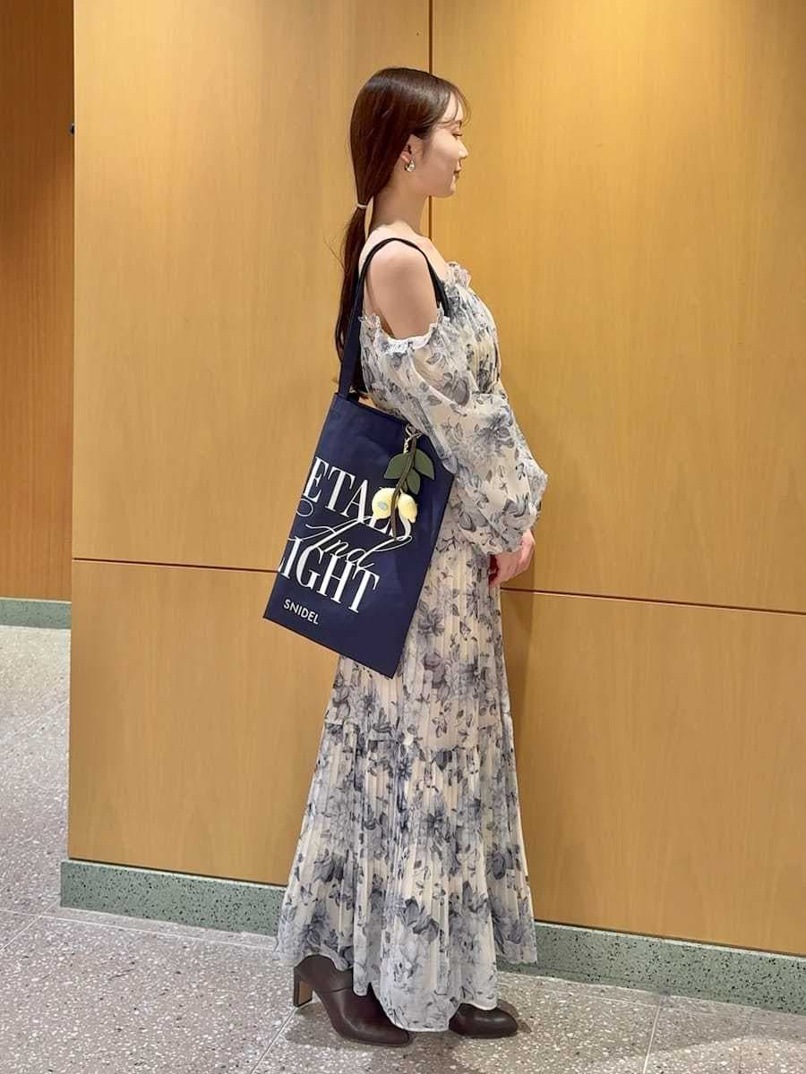 ブルー系のブルゾン、イエロー系のワンピース、ブルー系のトートバッグを着用したレディースの冬コーディネートの4枚目の写真