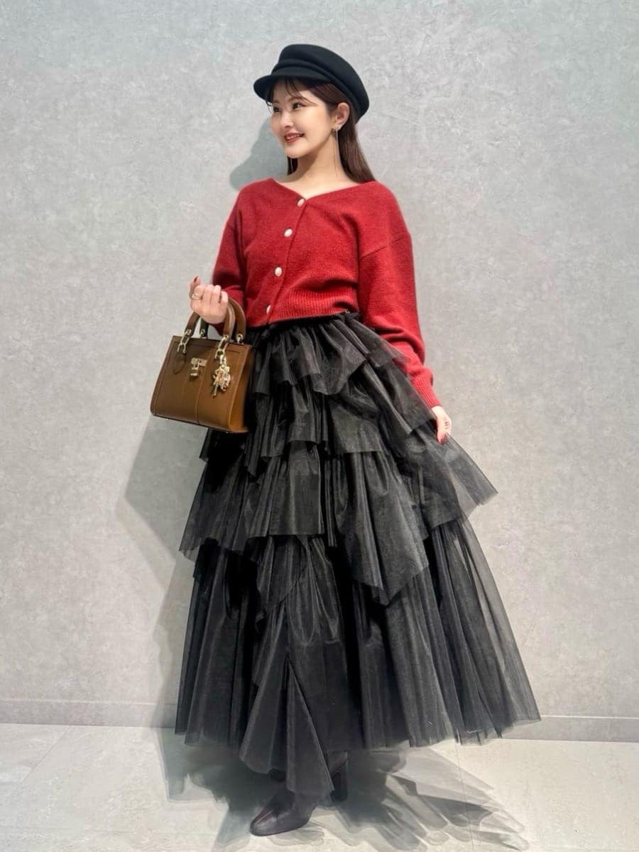 レッド系のブーツ、レッド系のカーディガン/ボレロ、ブラウン系のハンドバッグを着用したレディースの冬コーディネートの4枚目の写真