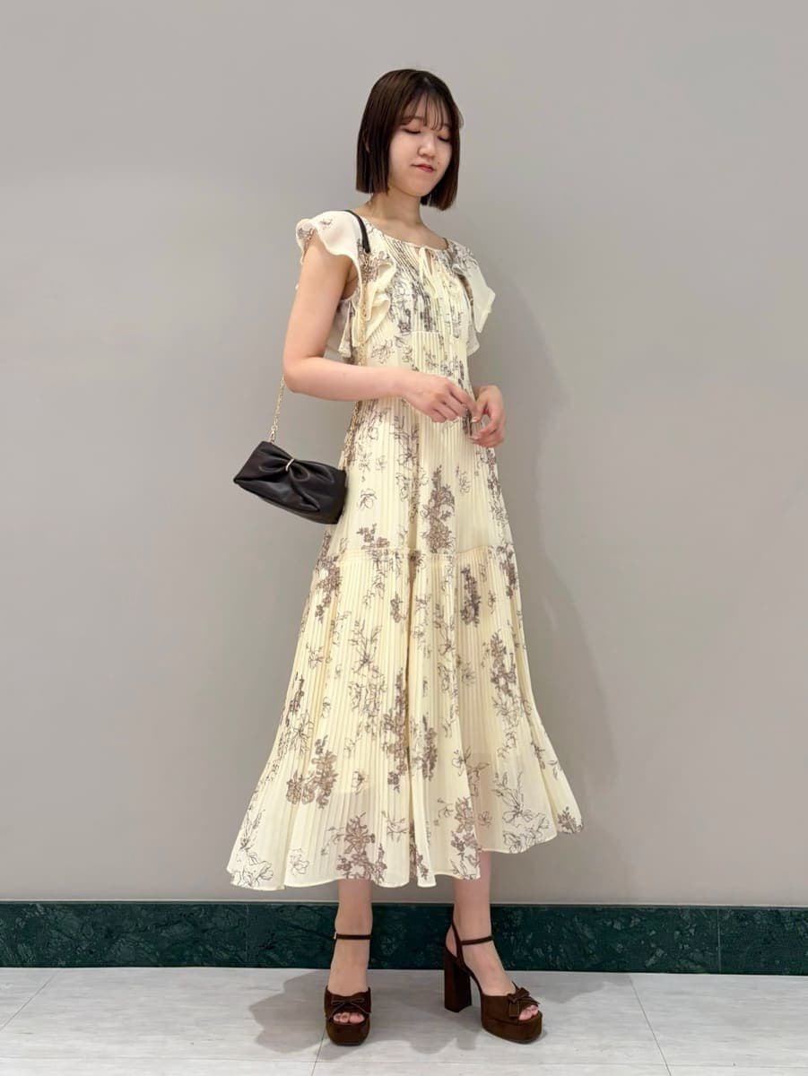 イエロー系のワンピース、ブラウン系のサンダルを着用したレディースの夏コーディネートの2枚目の写真