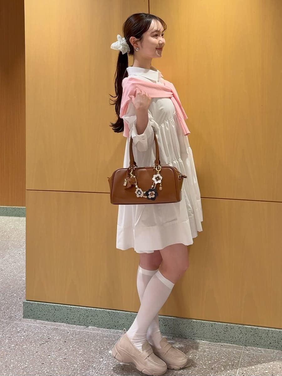 ホワイト系のワンピース、レッド系のカーディガン/ボレロ、イエロー系のボストンバッグを着用したレディースの春コーディネートの3枚目の写真