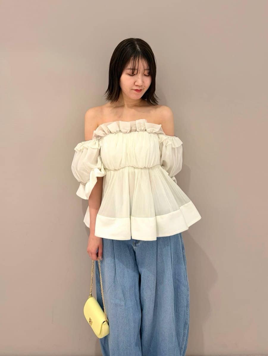 ブルー系のデニムパンツ、ホワイト系のその他トップス、イエロー系のショルダーバッグを着用したレディースの春コーディネートの2枚目の写真