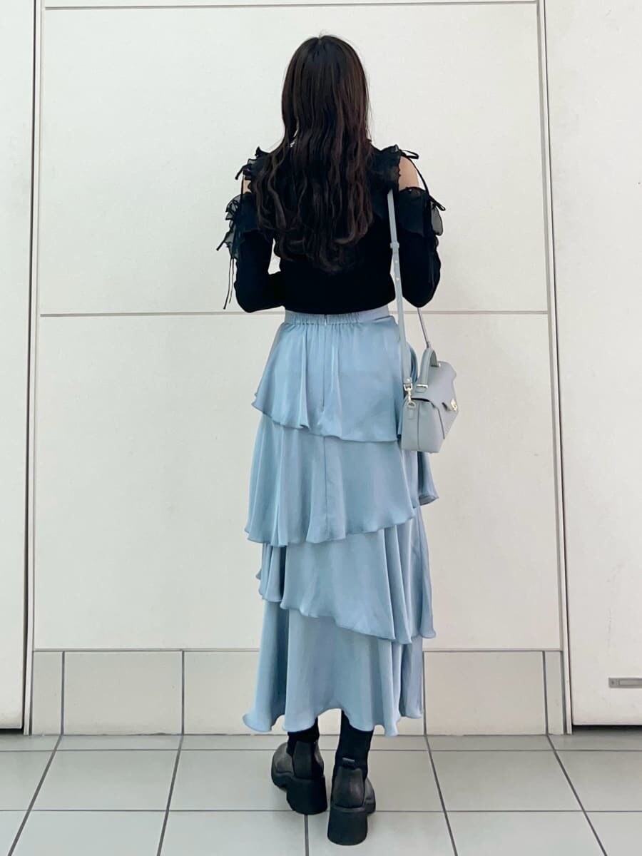 ブラック系のニット/セーター、ブルー系のスカート、ブルー系のショルダーバッグを着用したレディースの秋コーディネートの4枚目の写真