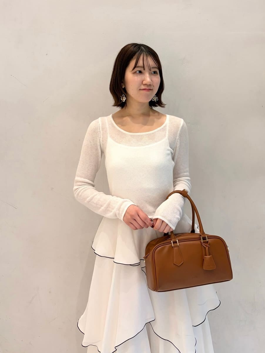 ホワイト系のワンピース、イエロー系のボストンバッグ、その他のイヤリングを着用したレディースの冬コーディネートの3枚目の写真