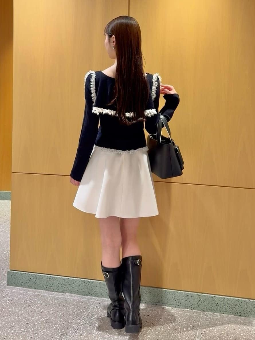 ブルー系のニット/セーター、ホワイト系のその他パンツ、ブラック系のハンドバッグを着用したレディースの冬コーディネートの4枚目の写真