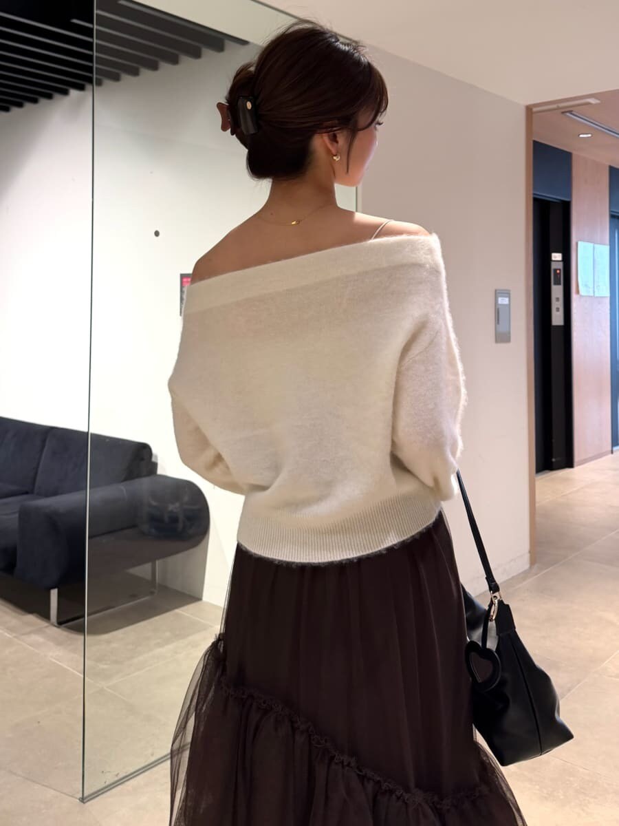 ブラウン系のスカート、ホワイト系のニット/セーター、ブラック系のショルダーバッグを着用したレディースの秋コーディネートの5枚目の写真