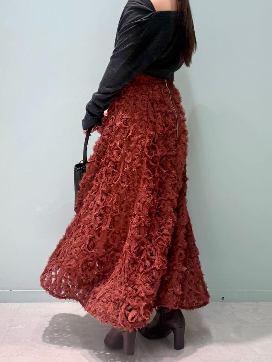 レッド系のブーツ、グレー系のチェスターコート、レッド系のスカートを着用したレディースの冬コーディネートの9枚目の写真