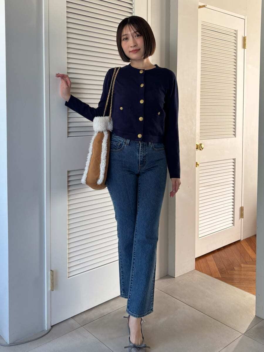 ブルー系のデニムパンツ、ブラウン系のハンドバッグを着用したレディースの秋コーディネートの8枚目の写真