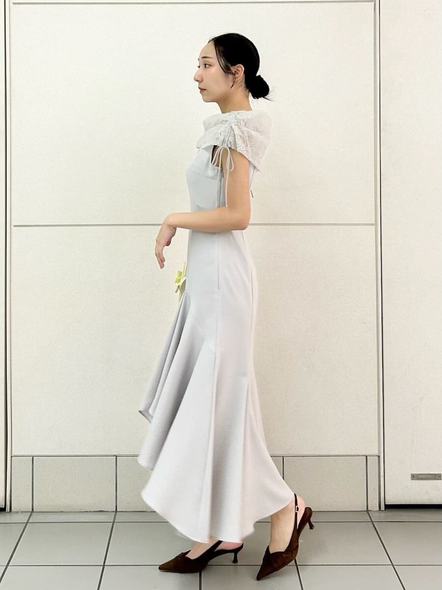 グレー系のドレス、ブラウン系のパンプス、イエロー系のショルダーバッグを着用したレディースの春コーディネートの2枚目の写真