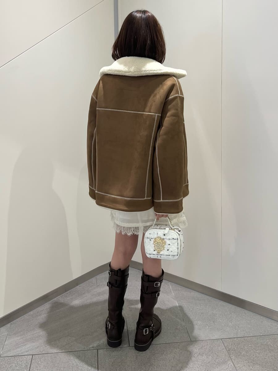 ホワイト系のワンピース、ブラウン系のブーツ、ホワイト系のショルダーバッグを着用したレディースの秋コーディネートの3枚目の写真